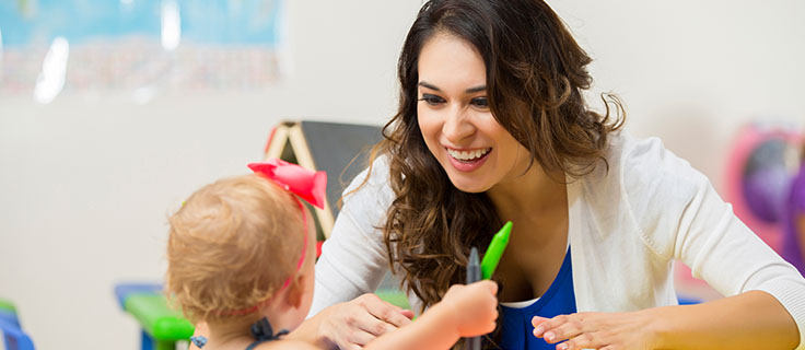 early childhood educator playing with student.