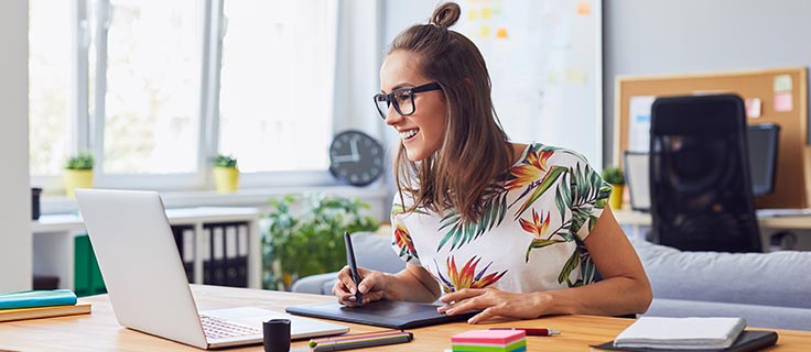 graphic designer using laptop and drawing tablet.