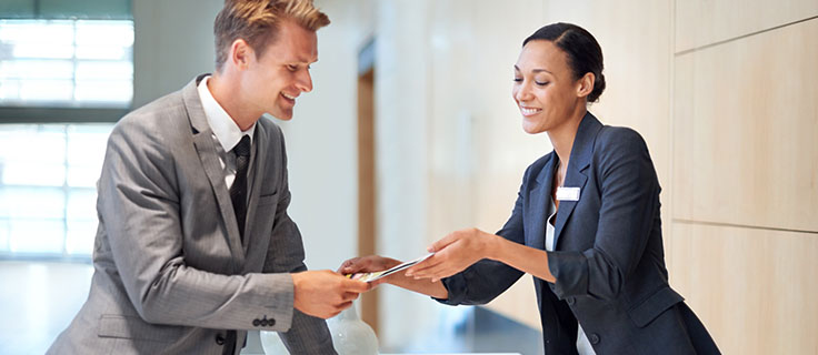 guest service agent shows guest brochure.