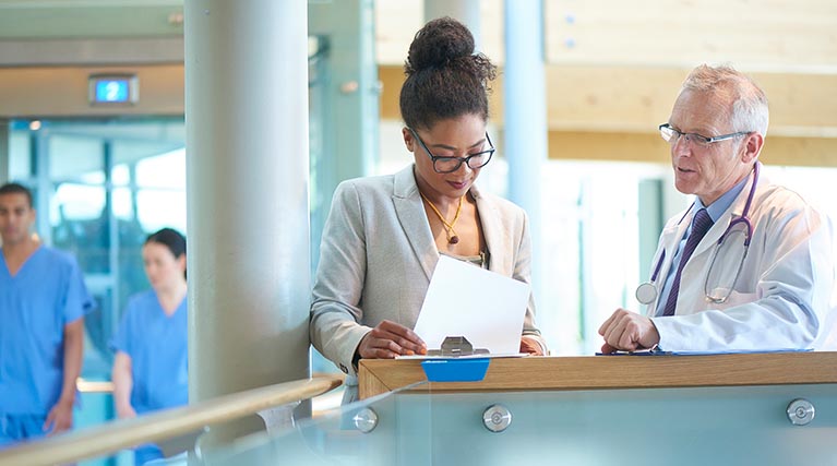 health care manager and doctor looking at documents.