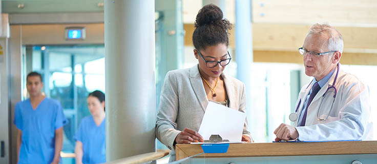 health care manager and doctor looking at documents.