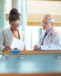 health care manager and doctor looking at documents.