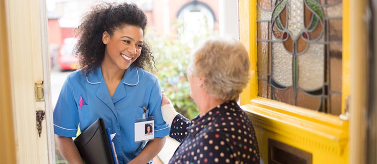 patient greets home nurse at front door.