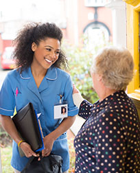patient greets home nurse at front door.