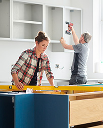 two people remodeling a home kitchen.