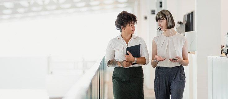 two human resource professionals talking at work.