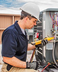 HVACR technician working on commercial air conditioner.