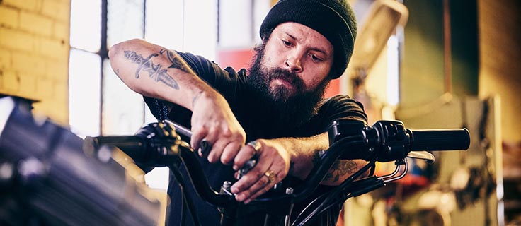 motorcycle repair technician working on handlebars.
