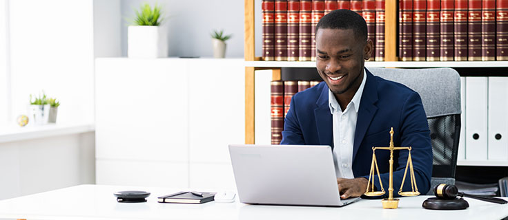 paralegal using laptop at desk.