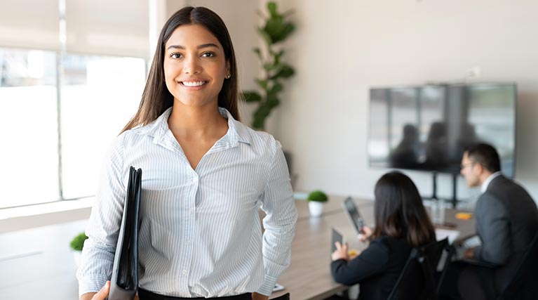 paralegal with folder standing in office.