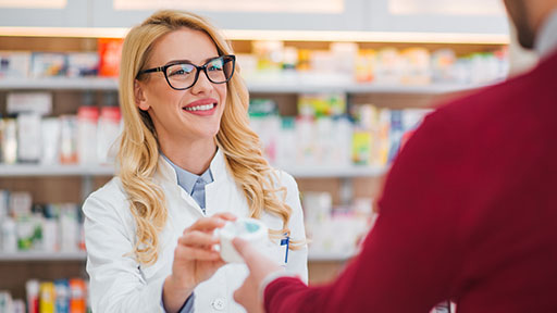 pharmacy technician assisting customer.