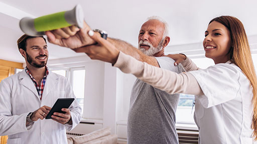 physical therapy aide helping patient.