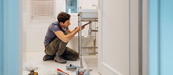 plumber fixing bathroom sink drain.