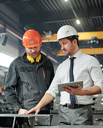 supervisor talking to employee in an industrial workspace.