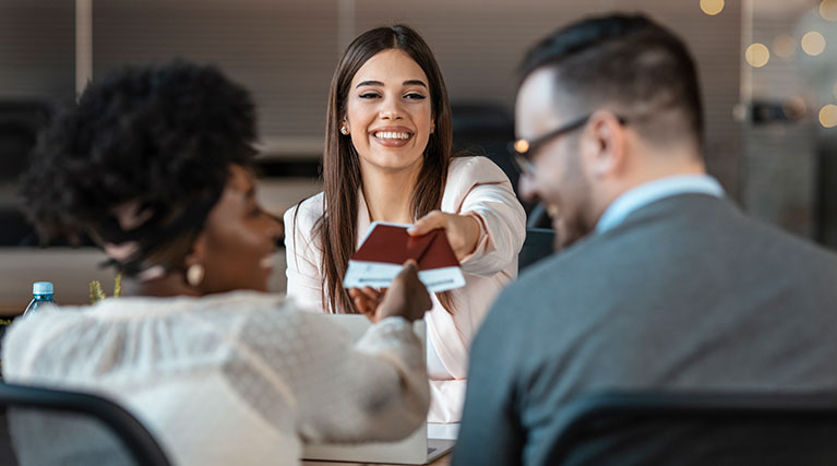 travel agent handing passports and tickets to couple.