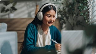 girl studying outside with headphones and laptop.