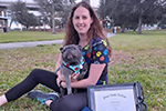 Penn Foster Vet Tech graduate posing with degree and dogs.