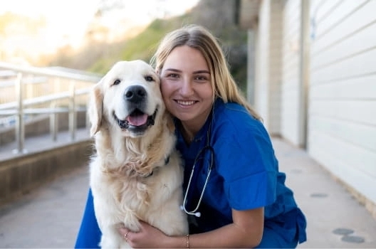 vet worker with smiling dog.