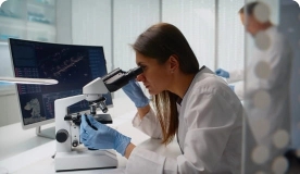 lab worker looking in a microscope.