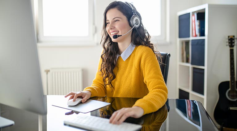 virtual assistant with headset works at her desk.