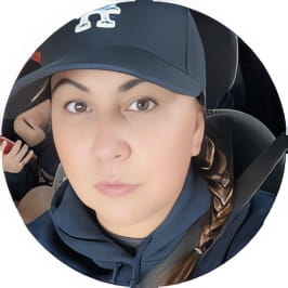 Penn Foster graduate in navy blue ball cap and hoodie posing for selfie in driver seat of car. 